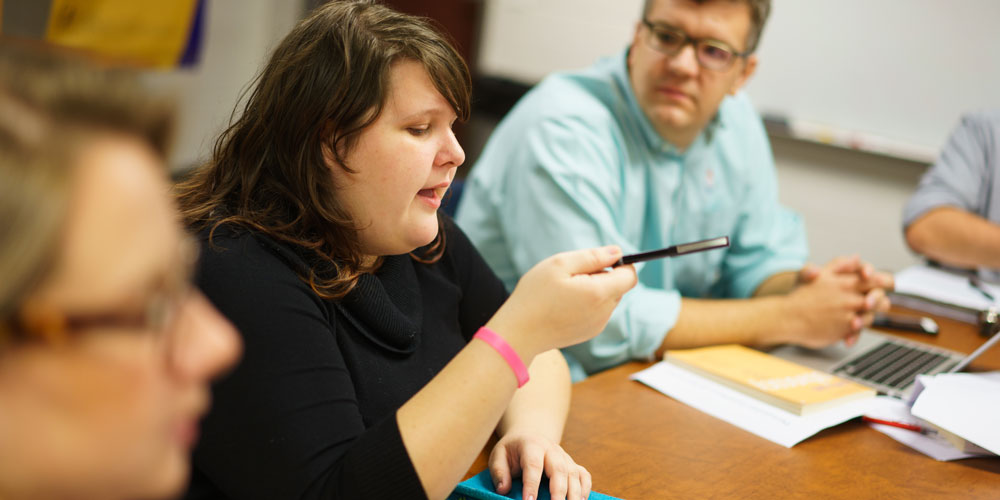 A graduate student makes an emphatic point to her classmates