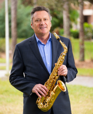 man standing with alto saxophone
