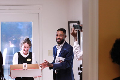 Furious Flower staff member Tara Dolan presents Gbenga with a cake in celebration of his book launch.