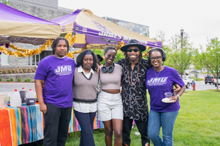 A group of international students smile for a photo in ISSS lawn party