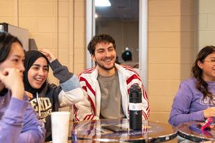 Ouail smiling while playing trivia with group