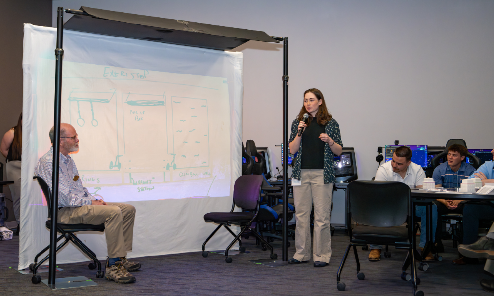 A Solutions Showcase attendee shares their reimagined bus stop experience with a student.