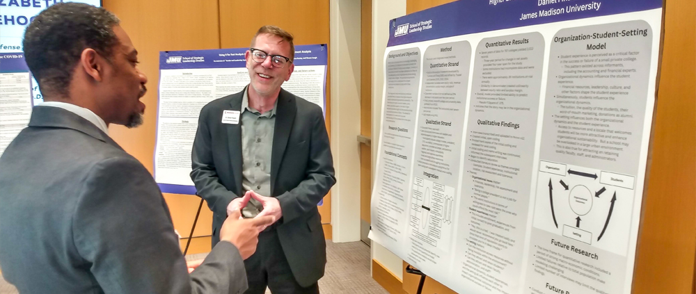 Two students discussing a research presentation board