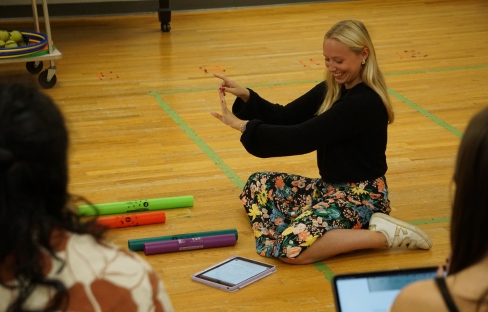 woman on the floor leading a music lesson