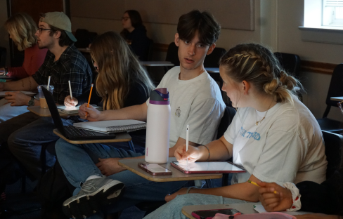 students in a classroom writing in notebooks