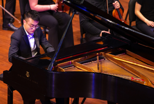 Pianist performing onstage with orchestra