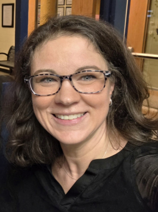 Woman with glasses smiling at camera