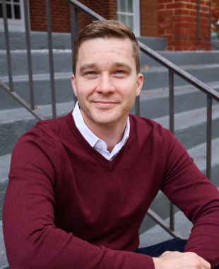 Man sitting on stairs smiling at camera