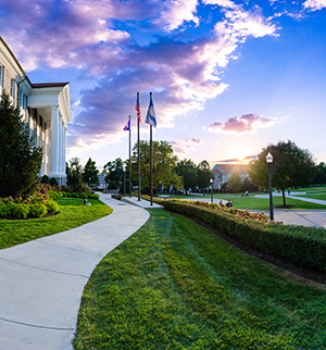 Sunset looking out down a sidewalk, over the Quad at JMU