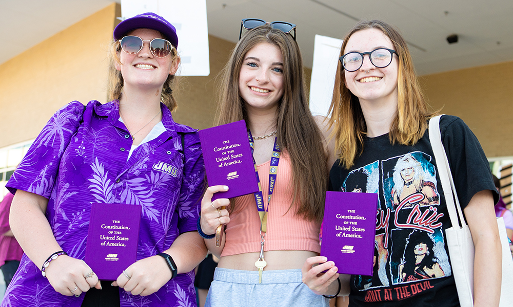 Students hold up Constitution books for the camera.