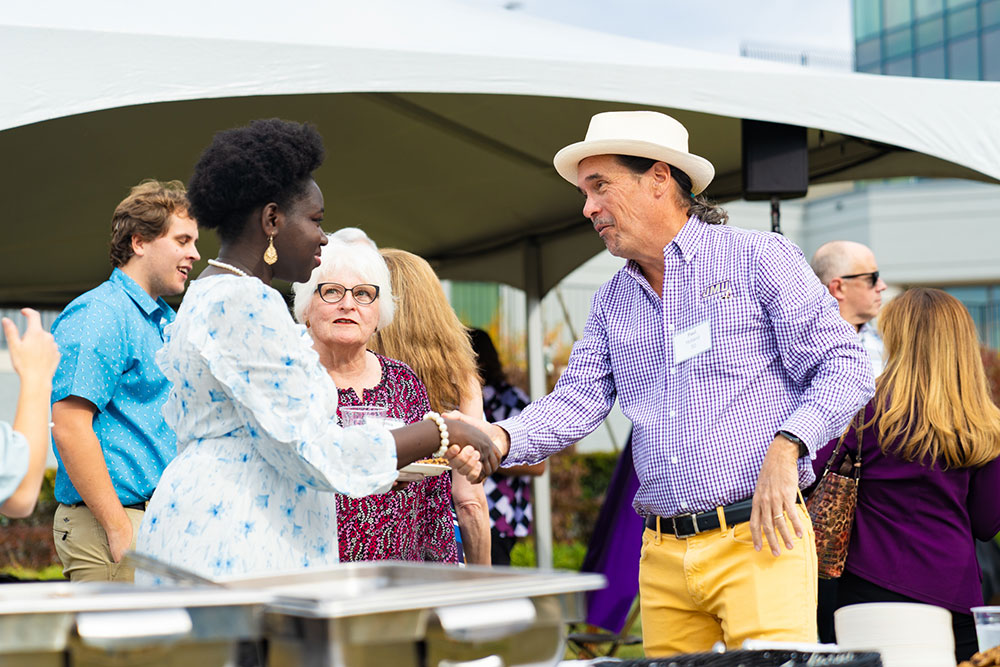 Holland greets Cynthia Skelley and student speaker N’Deye Sock, a junior communications and SMAD double major, outside of the about-to-be unveiled Holland Yates Hall