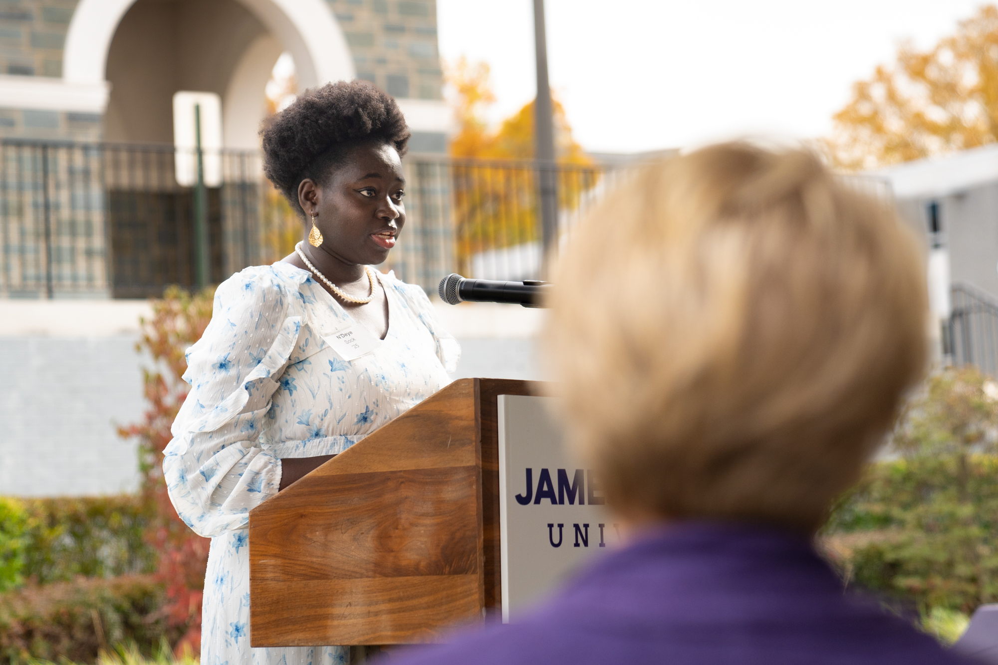 N’Deye Sock speaks behind a podium at the event