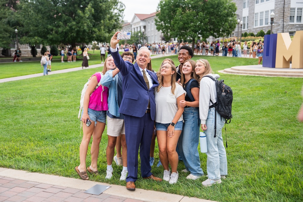 Students taking a selfie with President Jim Schmidt