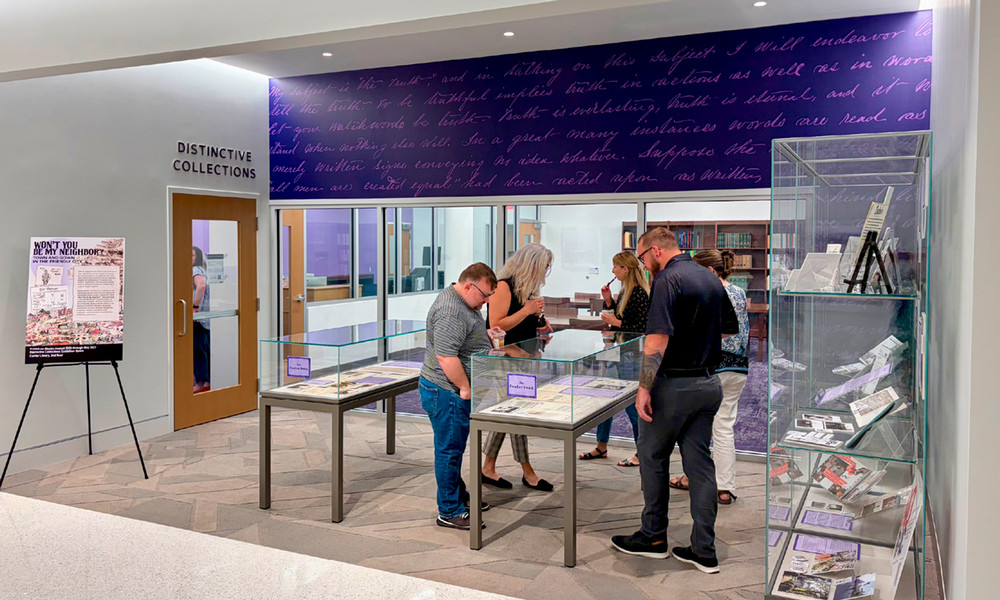 The Distinctive Collections entrance features an exhibit gallery and a purple wall with writing from an excerpt from writings by George A. Newman.