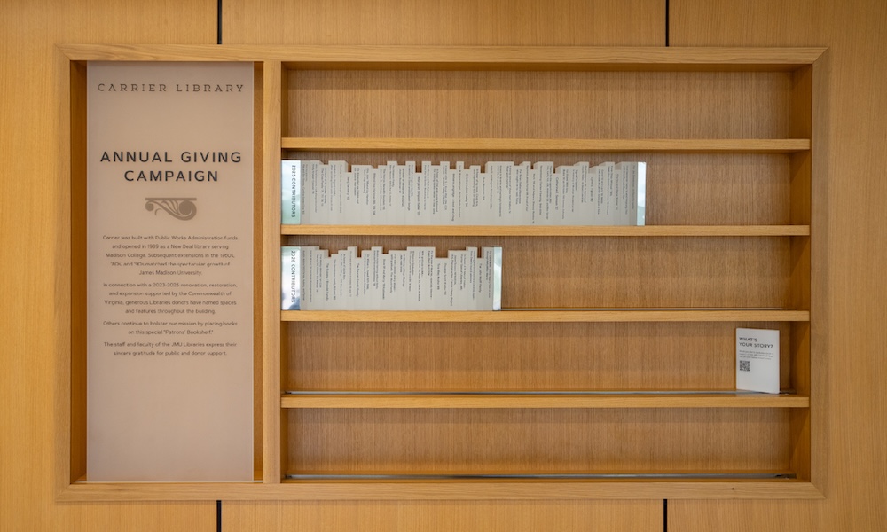 The Patrons’ Bookshelf features glass “books” that show the names of donors who supported the Libraries.