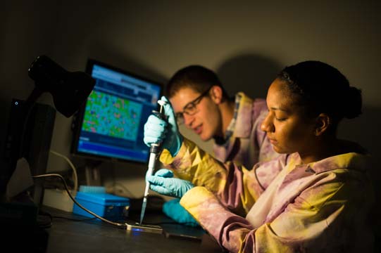 Jesmine Roberts-Torres and a classmate use a DNA sequencer in a JMU lab
