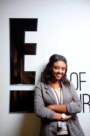 Mia Bragham stands next to a sign for E! entertainment, where she completed an internship