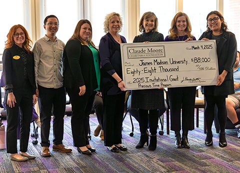 Faculty and staff hold a check from the Claude Moore Foundation in a group photo.
