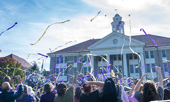 Parents, Faculty, Staff, and Students throw streamers in front of Wilson Hall after JMU guarantees announcement