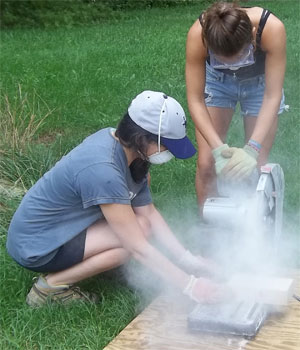 Students using diamond saw to cut a brick.