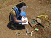 Daniele Ressler writing data on a pad in a Jordanian minefield