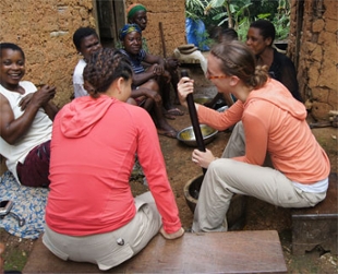 Students sit amongst villagers