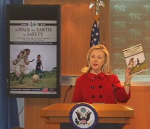 Hillary Rodham Clinton holds magazine during press conference.