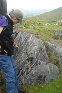 professor points to piece of marble in field
