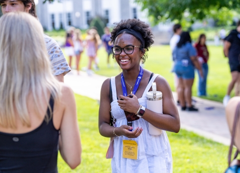 Student smiling while interacting with peers.