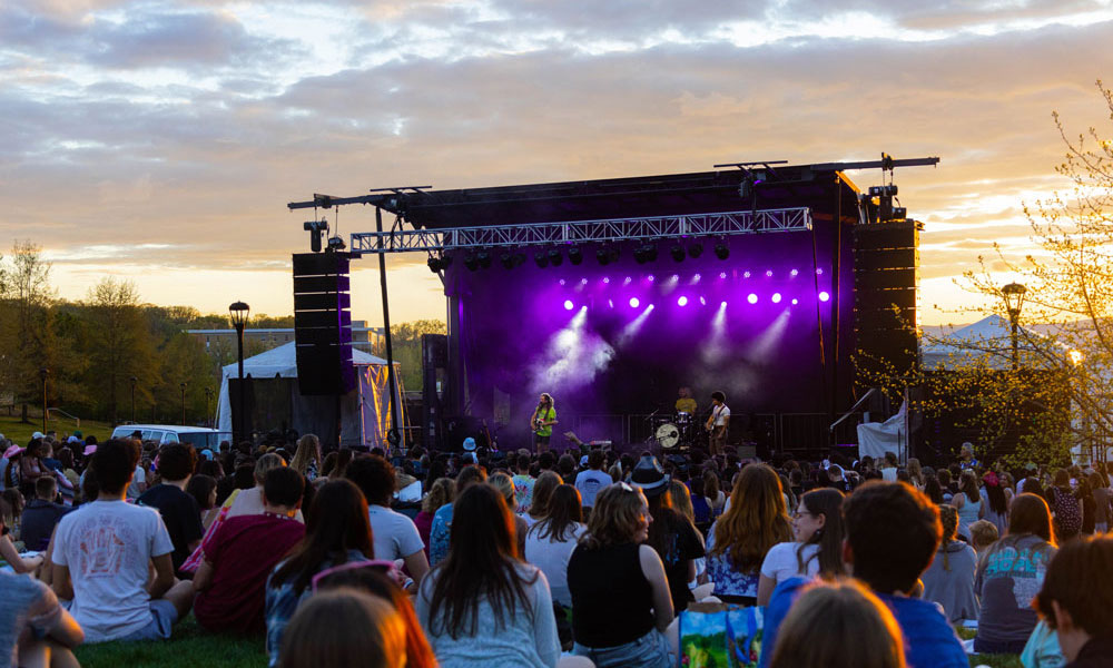 Crowd of students outside in front of a stage on Festival Lawn