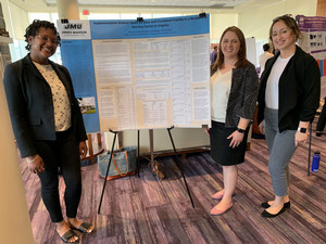 Students standing by graduate poster