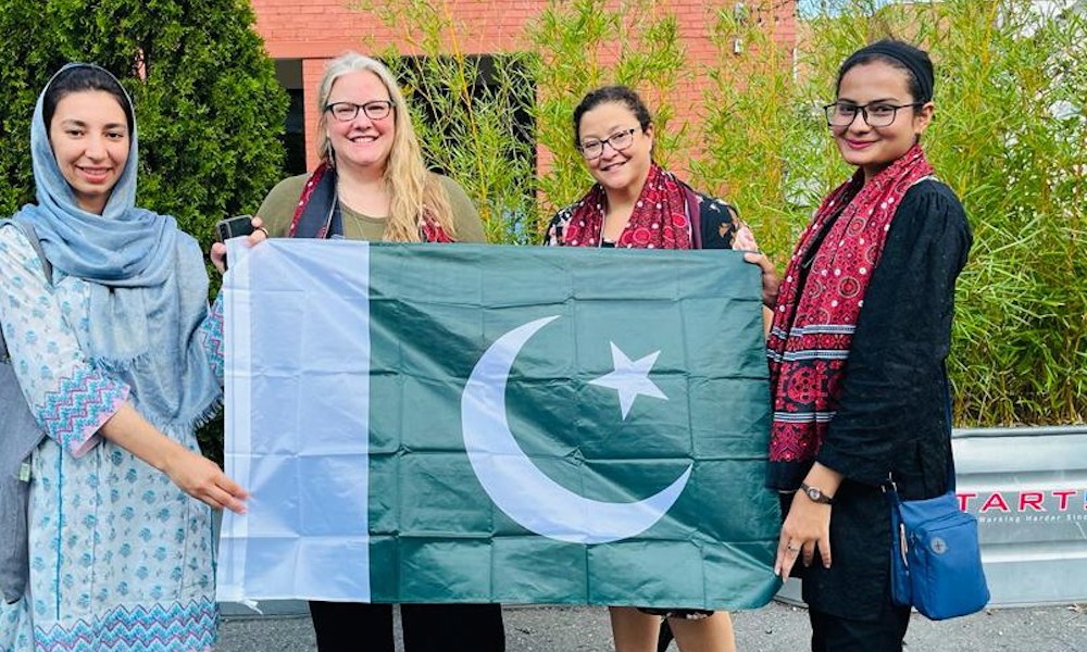 Image of Sister2Sister students holding Pakistani flag with JMU faculty
