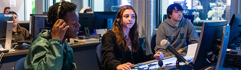 Students collaborate at the switcher in the SMAD studio control room. 
