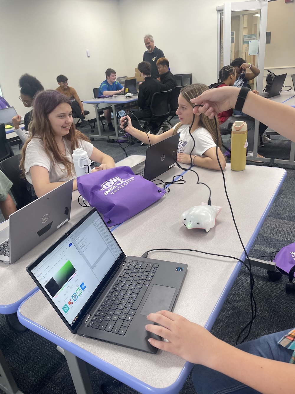 Students use laptops and cables to program the finch robots