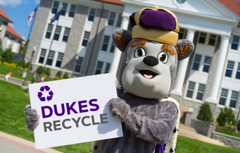 School mascot holding sign promoting recycling