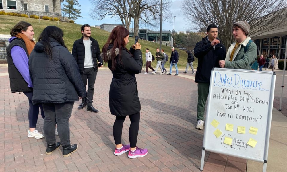 <span class="submesa"><span class="slidetitle">Dukes Discourse</span></span> Dukes discourse whiteboard and students at Warner Commons